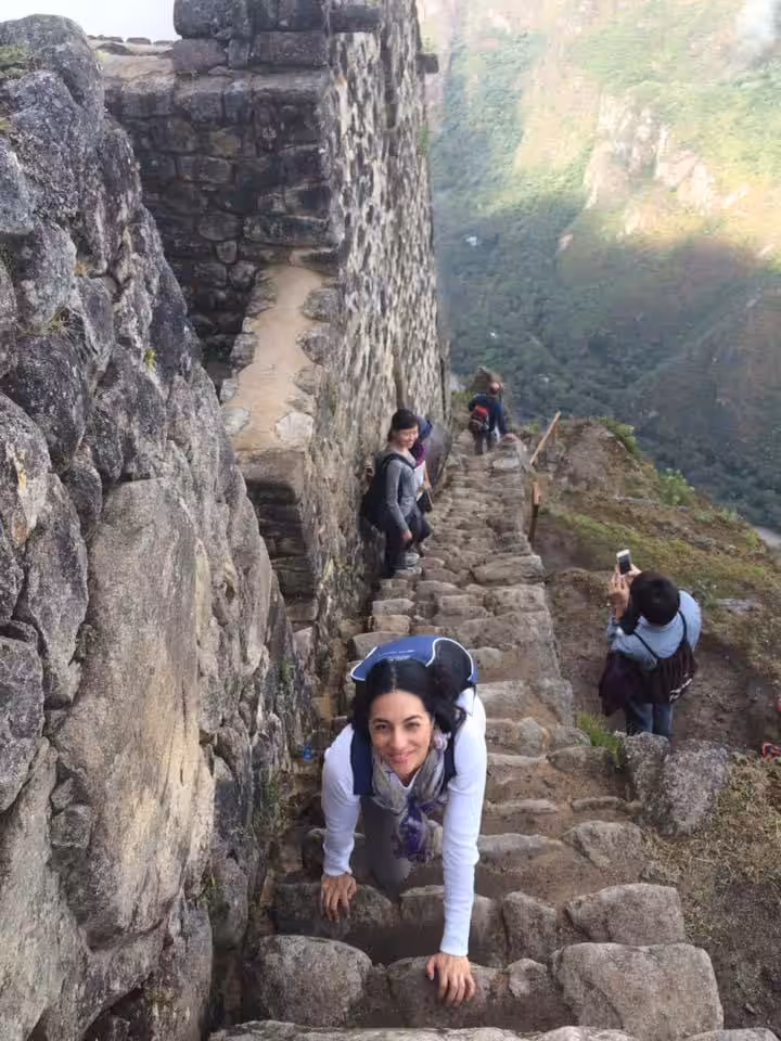 Les gens marchent dans des escaliers en pierre étroits sur un sentier de montagne.