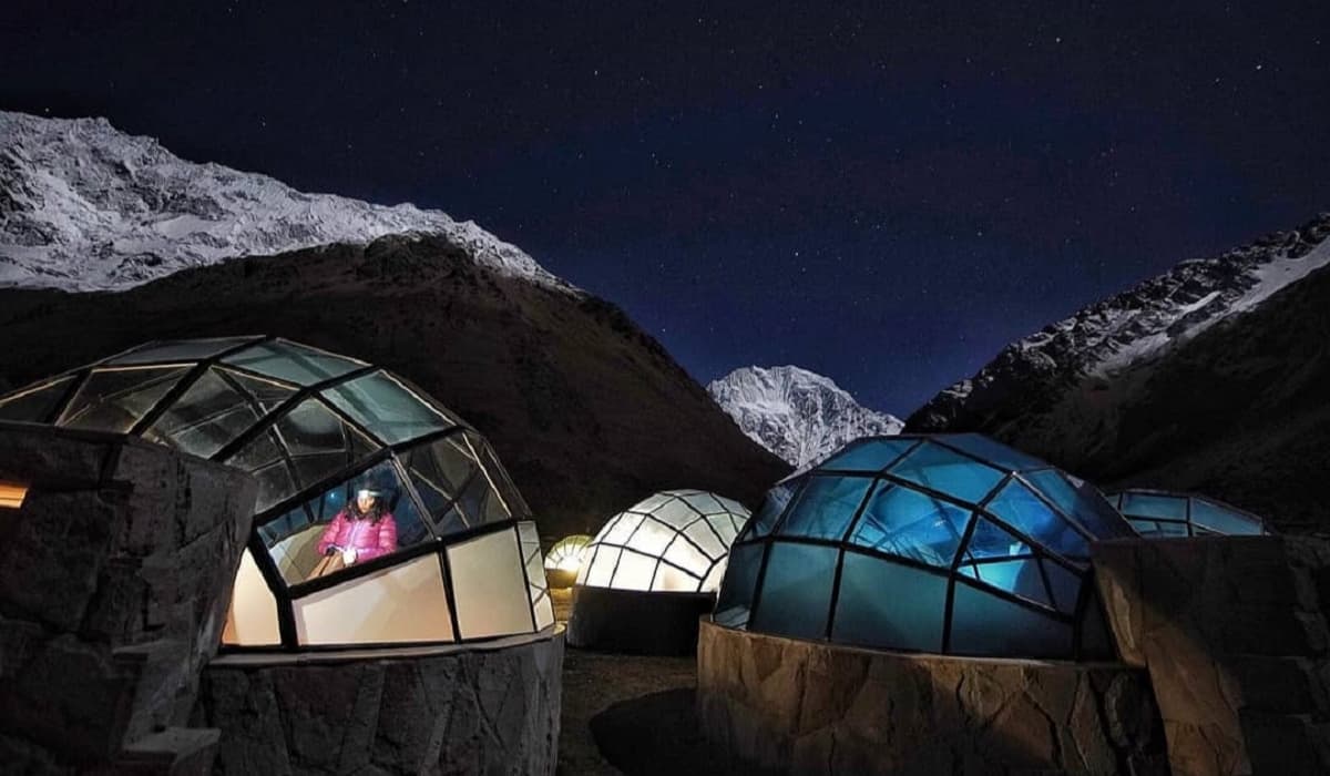 Mountain igloos under a starlit sky at night.