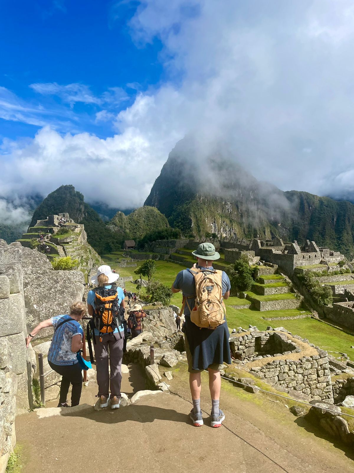 Tourists exploring Machu Picchu ruins in sunlight in Inca Trail